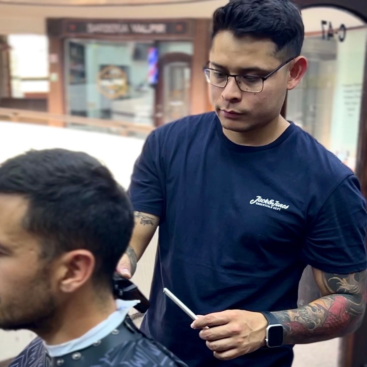 Barbero de EXOR Barber Studio realizando un corte de precisión